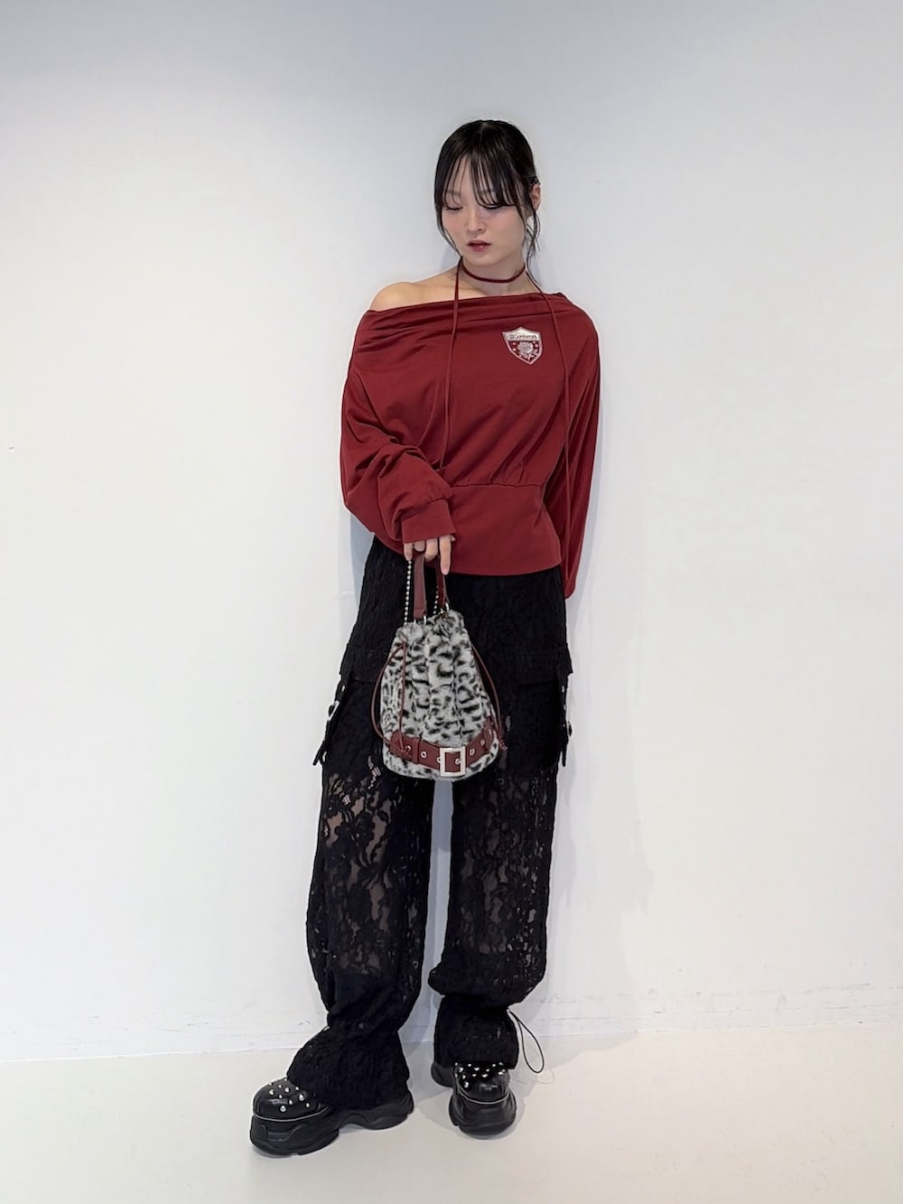 レッド系のTシャツ/カットソー、ブラック系のその他パンツ、グレー系のハンドバッグを着用したレディースの夏コーディネートの4枚目の写真