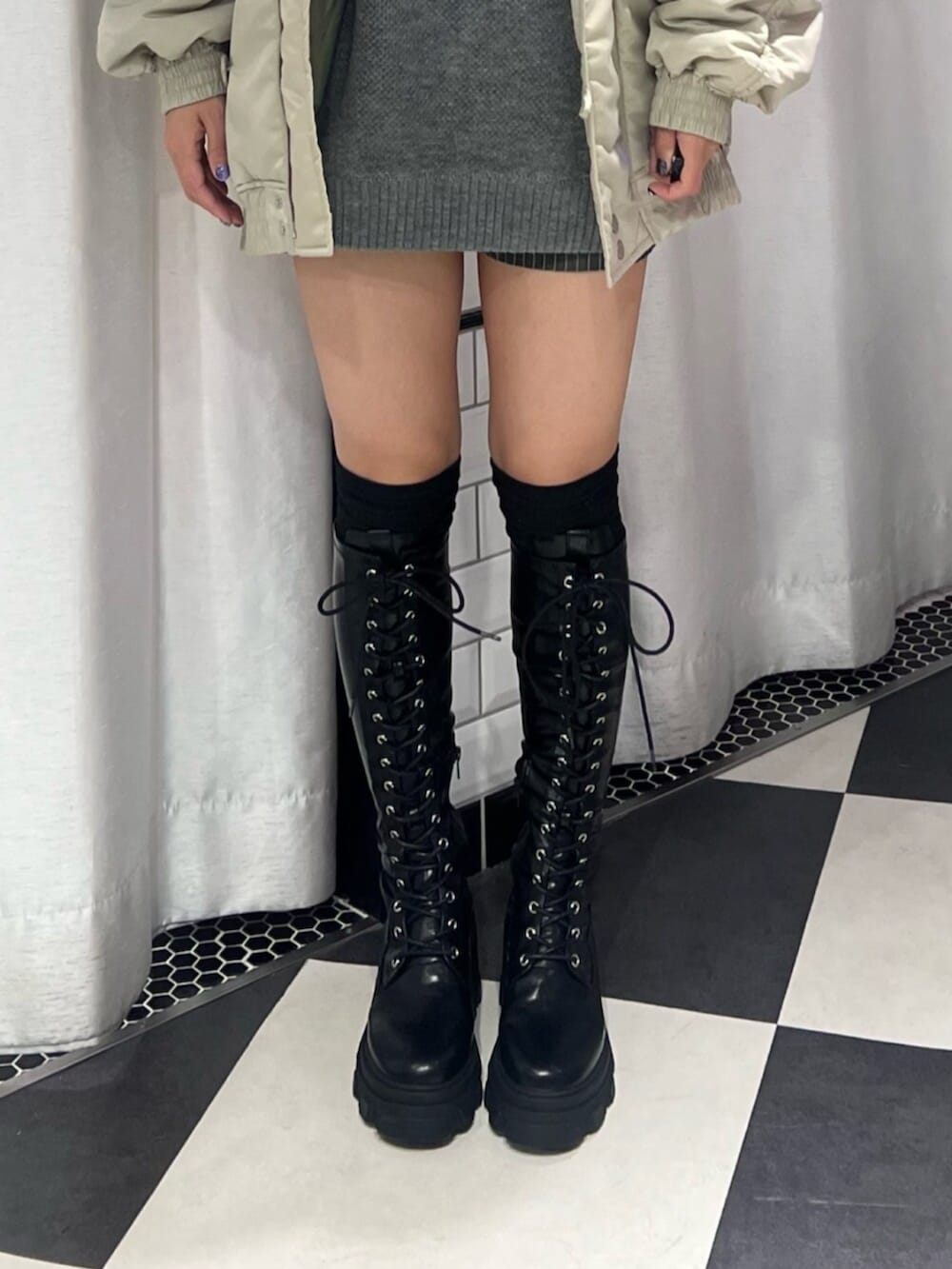 ブラック系のブーツ、ホワイト系のブルゾン、グレー系のニット/セーターを着用したレディースの秋コーディネートの6枚目の写真