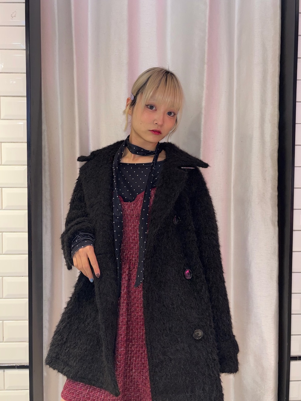 ブラック系のステンカラーコート、ブラック系のTシャツ/カットソー、レッド系のワンピースを着用したレディースの冬コーディネートの4枚目の写真