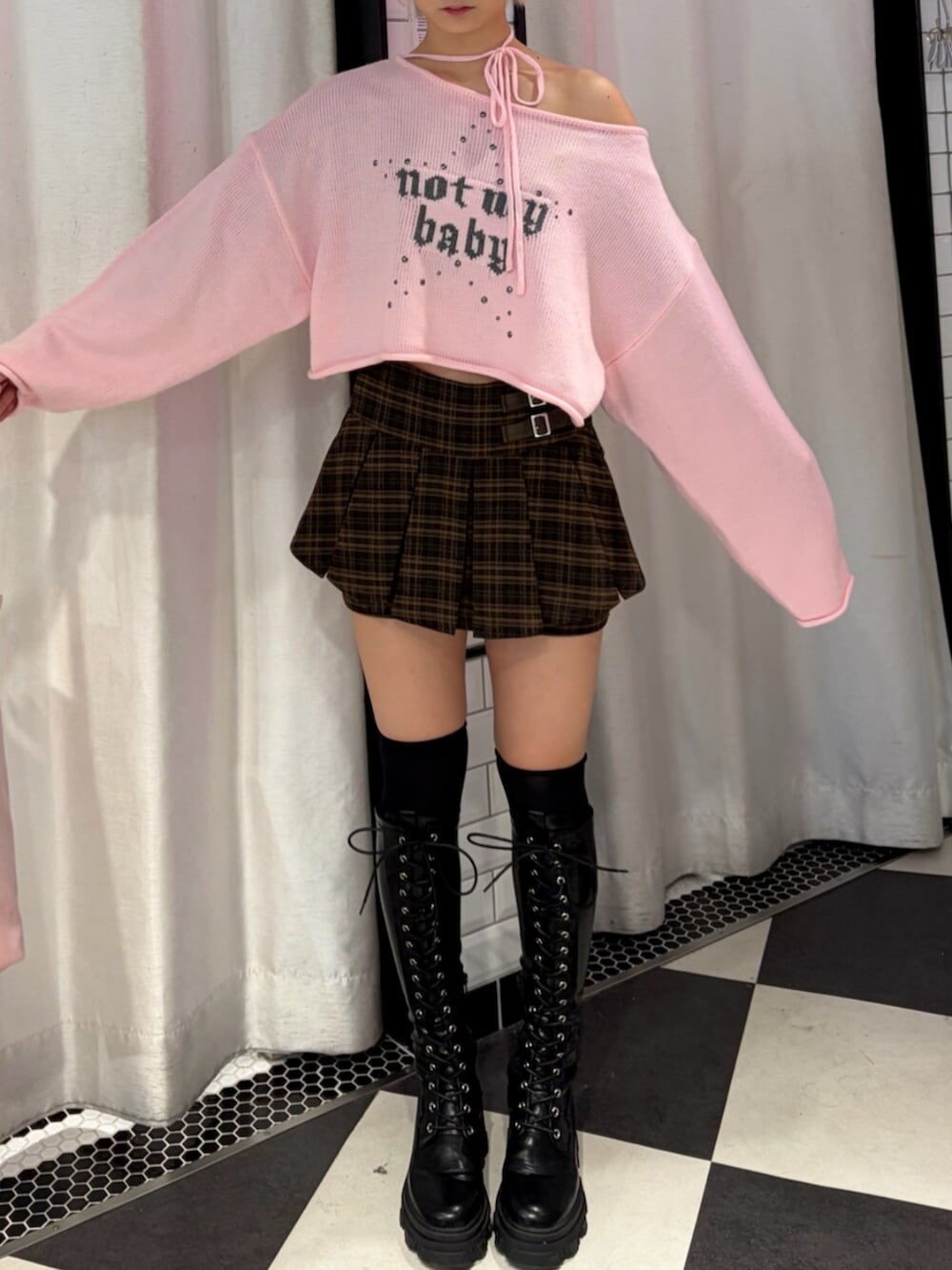 ブラック系のブーツ、ブラウン系のスカート、ピンク系のニット/セーターを着用したレディースの秋コーディネートの4枚目の写真