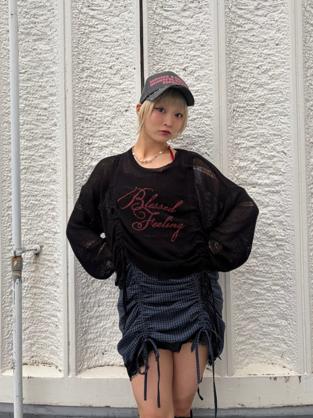 ブラック系のブーツ、ブラック系のニット/セーター、レッド系のキャミソールを着用したレディースの春コーディネートの6枚目の写真