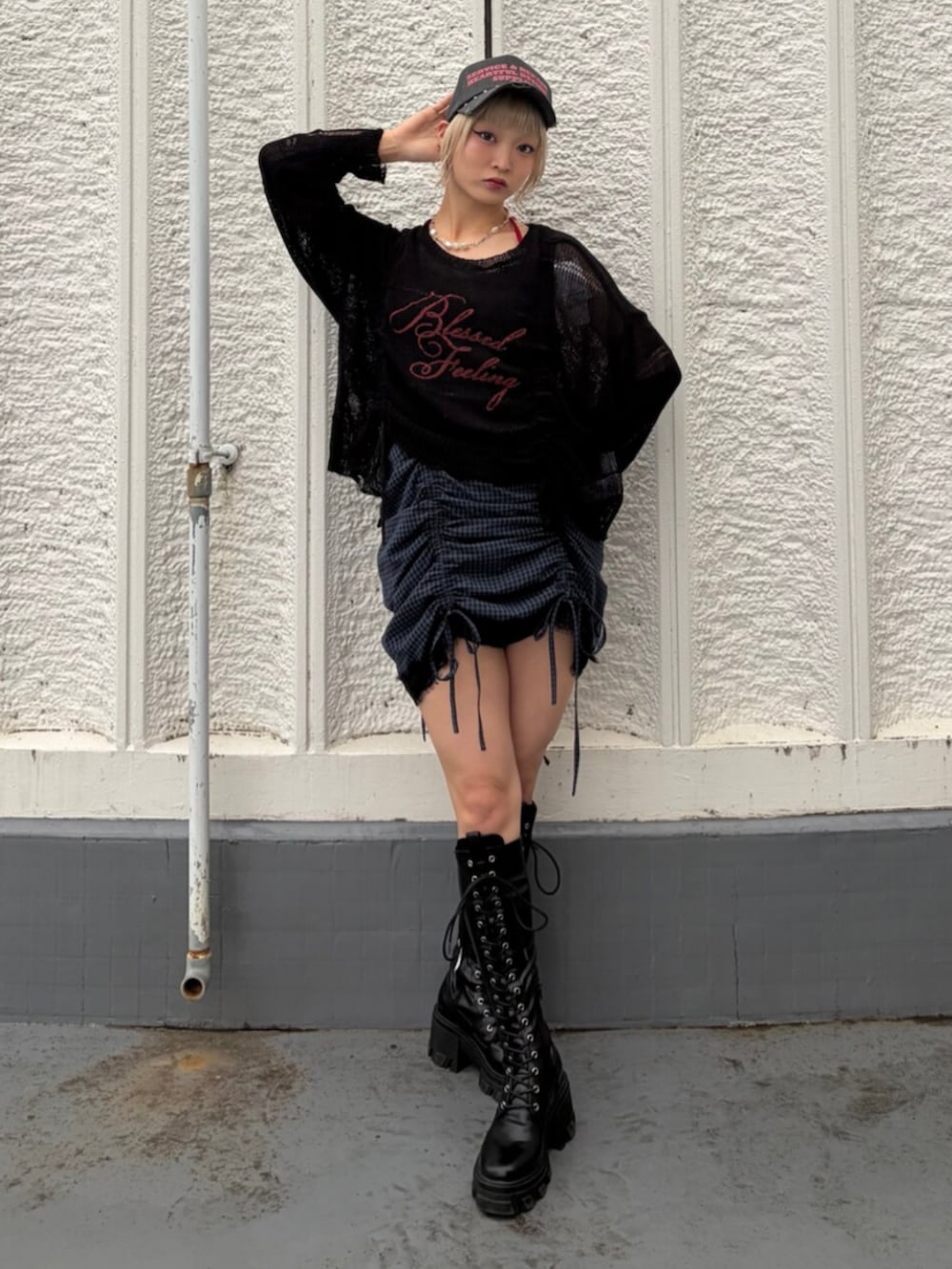 ブラック系のブーツ、ブラック系のニット/セーター、レッド系のキャミソールを着用したレディースの春コーディネートの2枚目の写真