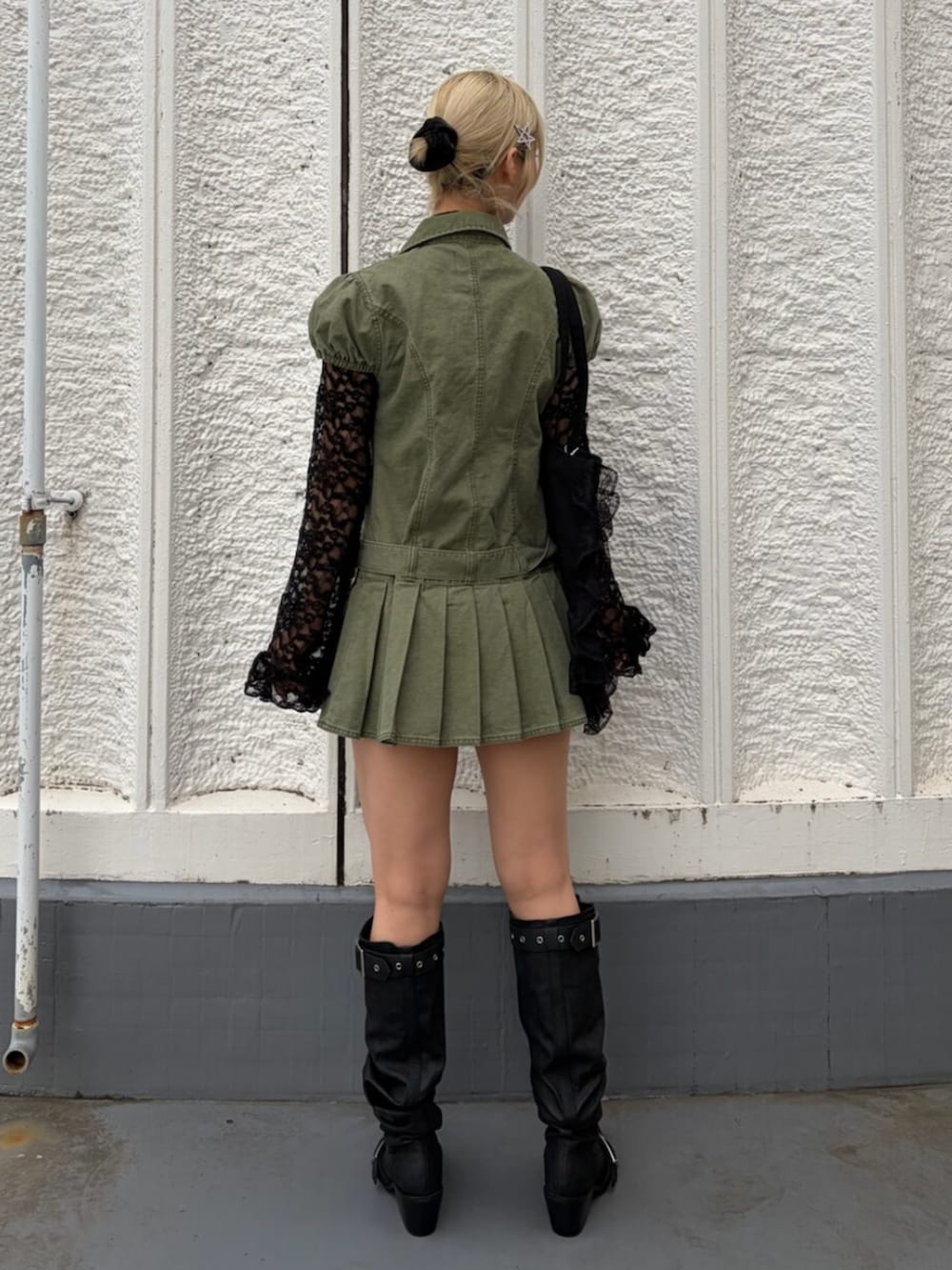 ブラック系のTシャツ/カットソー、ブラック系のブーツ、グリーン系のワンピースを着用したレディースの春コーディネートの4枚目の写真