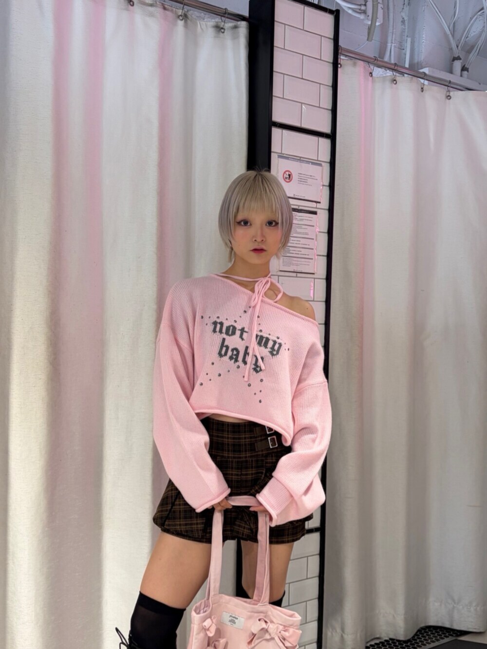 ブラック系のブーツ、ブラウン系のスカート、ピンク系のニット/セーターを着用したレディースの秋コーディネートの5枚目の写真