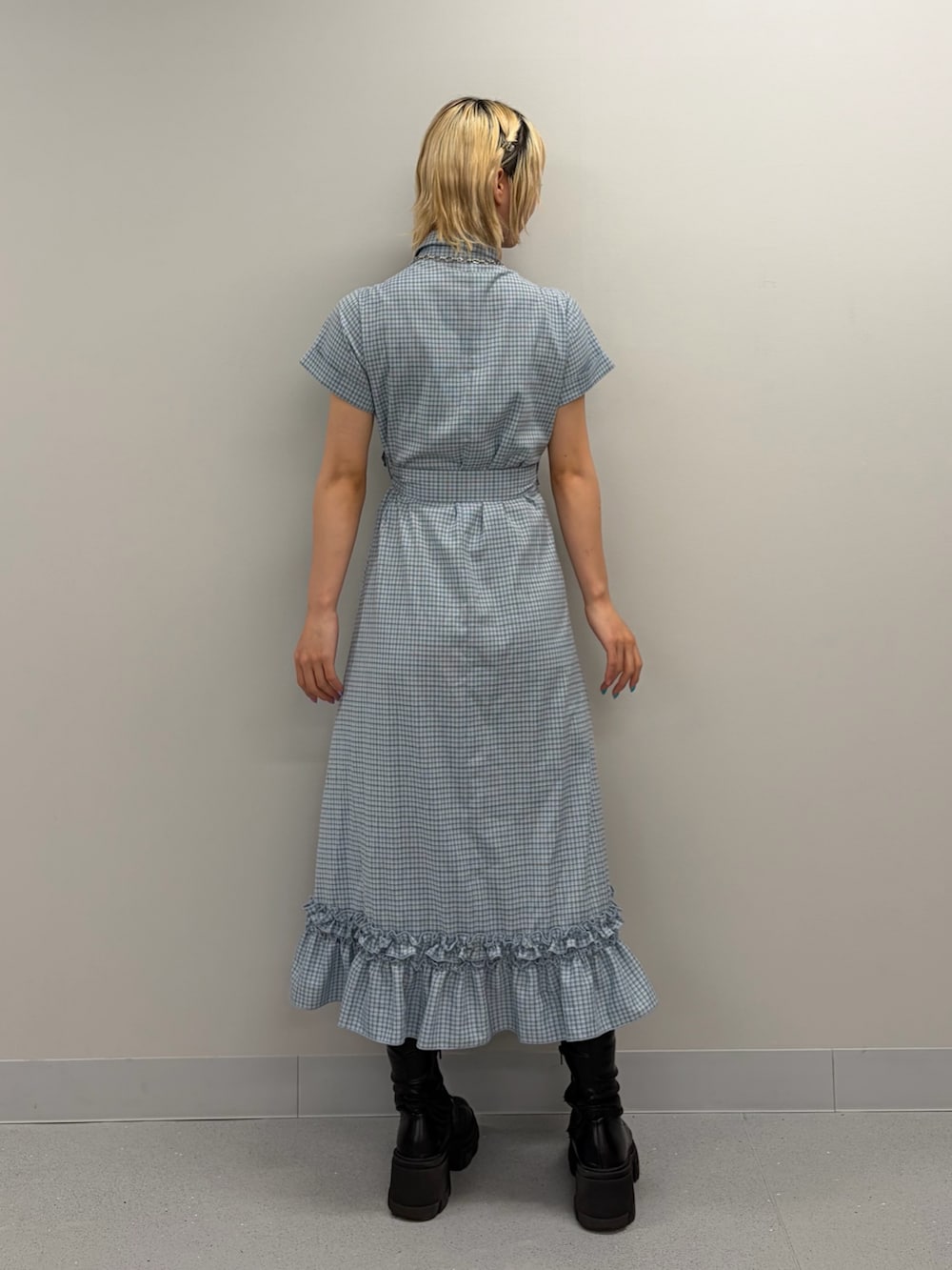 ブルー系のワンピース、ブラック系のブーツを着用したレディースの春コーディネートの3枚目の写真