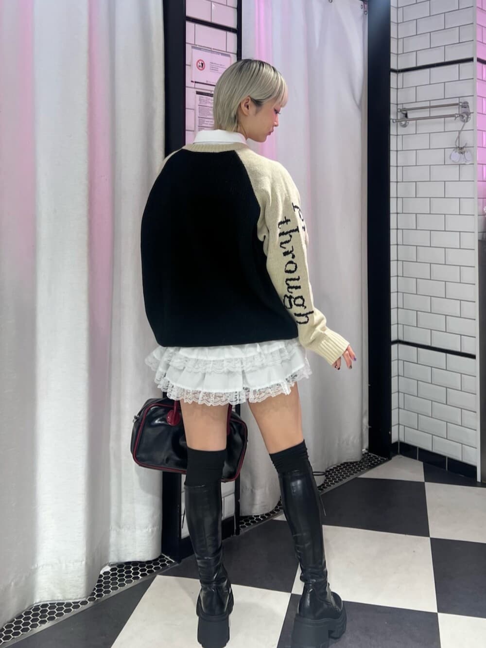 ブラック系のボストンバッグ、ブラック系のブーツ、ブラック系のニット/セーターを着用したレディースの秋コーディネートの3枚目の写真