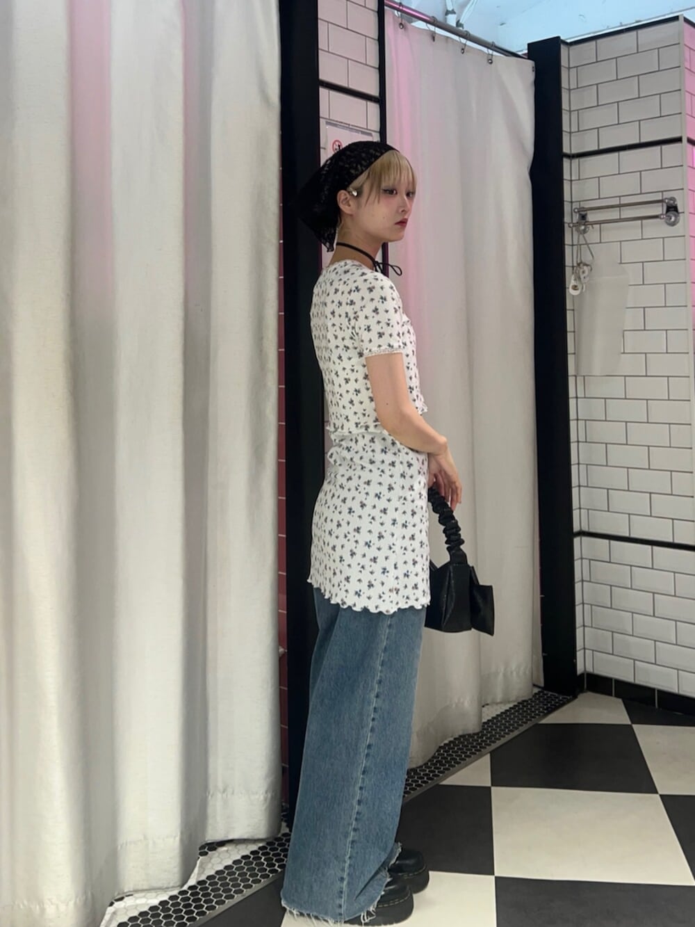 ブラック系のハンドバッグ、ホワイト系のカーディガン/ボレロ、ホワイト系のワンピースを着用したレディースの春コーディネートの2枚目の写真