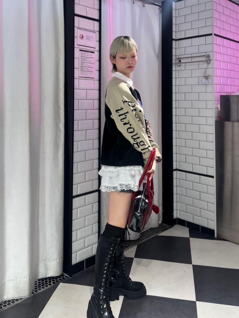 ブラック系のボストンバッグ、ブラック系のブーツ、ブラック系のニット/セーターを着用したレディースの秋コーディネートの2枚目の写真