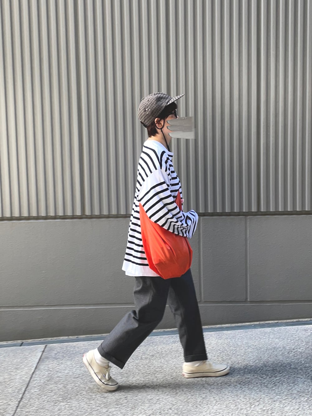 グレー系のスラックス、ホワイト系のTシャツ/カットソー、ホワイト系のスニーカーを着用したレディースの秋コーディネートの2枚目の写真