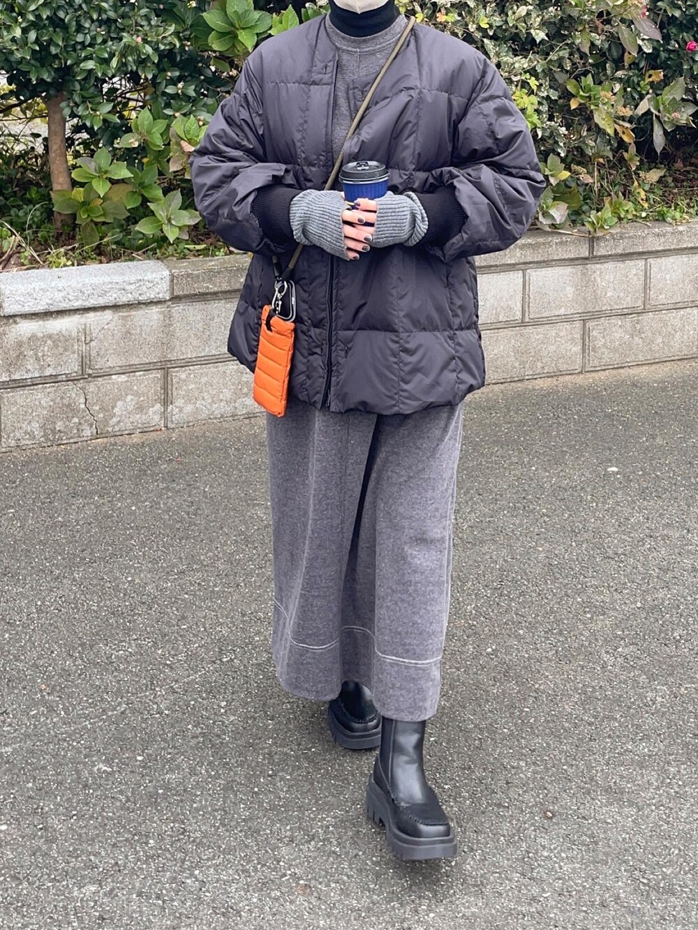 ブラック系のワンピース、ブラック系のブーツ、ブラック系のニット/セーターを着用したレディースの冬コーディネートの2枚目の写真