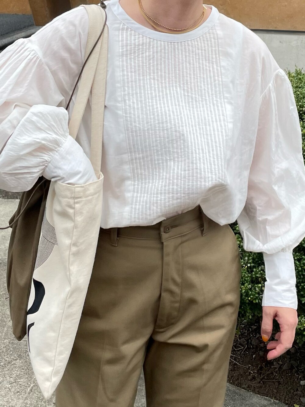 ホワイト系のシャツ/ブラウス、ベージュ系のチノパンツを着用したレディースの秋コーディネートの2枚目の写真