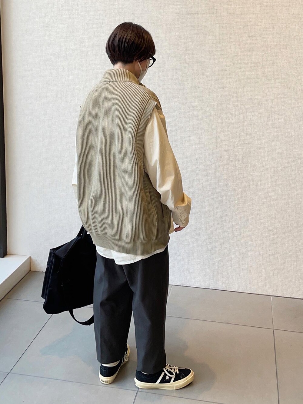 ブラック系のスニーカー、グレー系のスラックス、ベージュ系のシャツ/ブラウスを着用したレディースの秋コーディネートの2枚目の写真