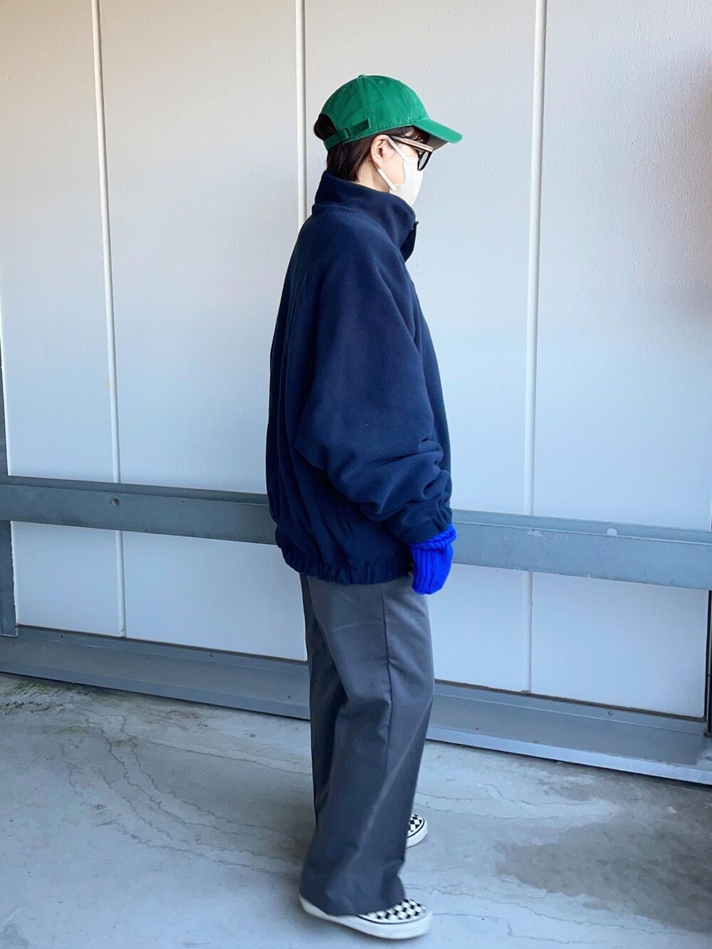 グレー系のスラックス、ブルー系のブルゾン、ホワイト系のスニーカーを着用したレディースの冬コーディネートの4枚目の写真