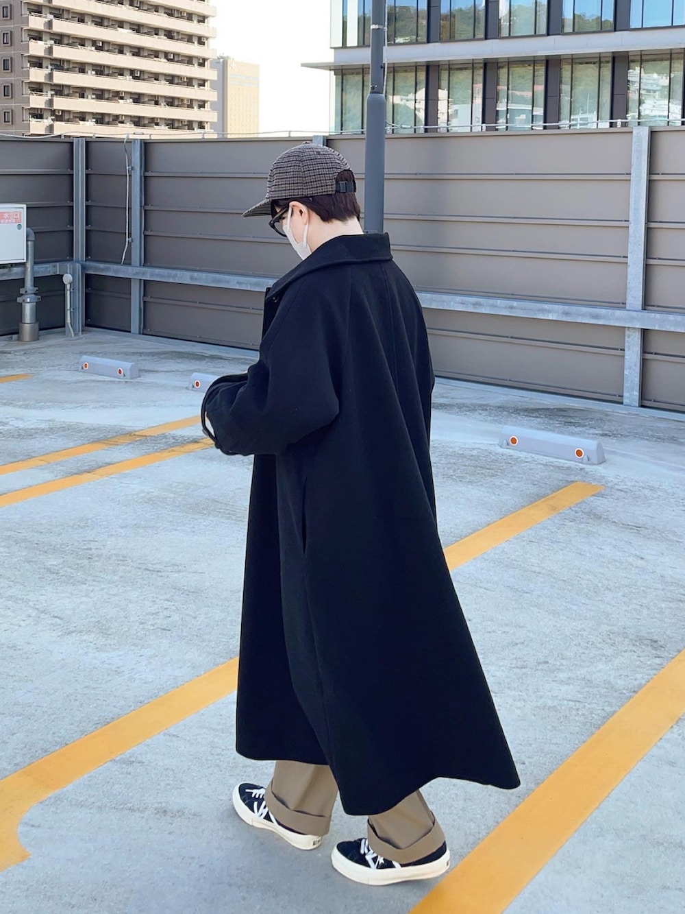 ブラック系のステンカラーコートを着用したレディースの秋コーディネートの2枚目の写真