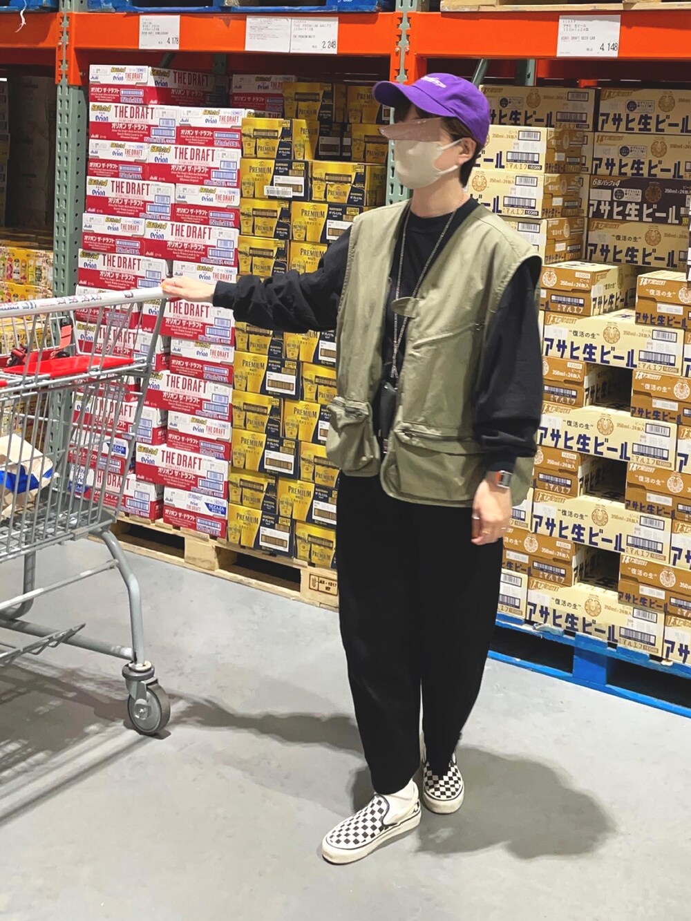 ブラック系のスウェットパンツ、ホワイト系のスニーカー、グリーン系のベストを着用したレディースの秋コーディネートの2枚目の写真