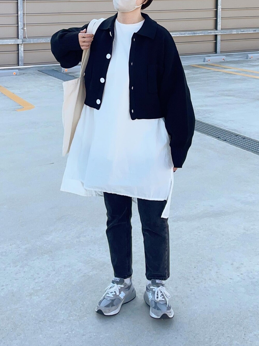 ブラック系のニット/セーター、グレー系のスニーカー、ブラック系のメガネを着用したレディースの秋コーディネートの2枚目の写真