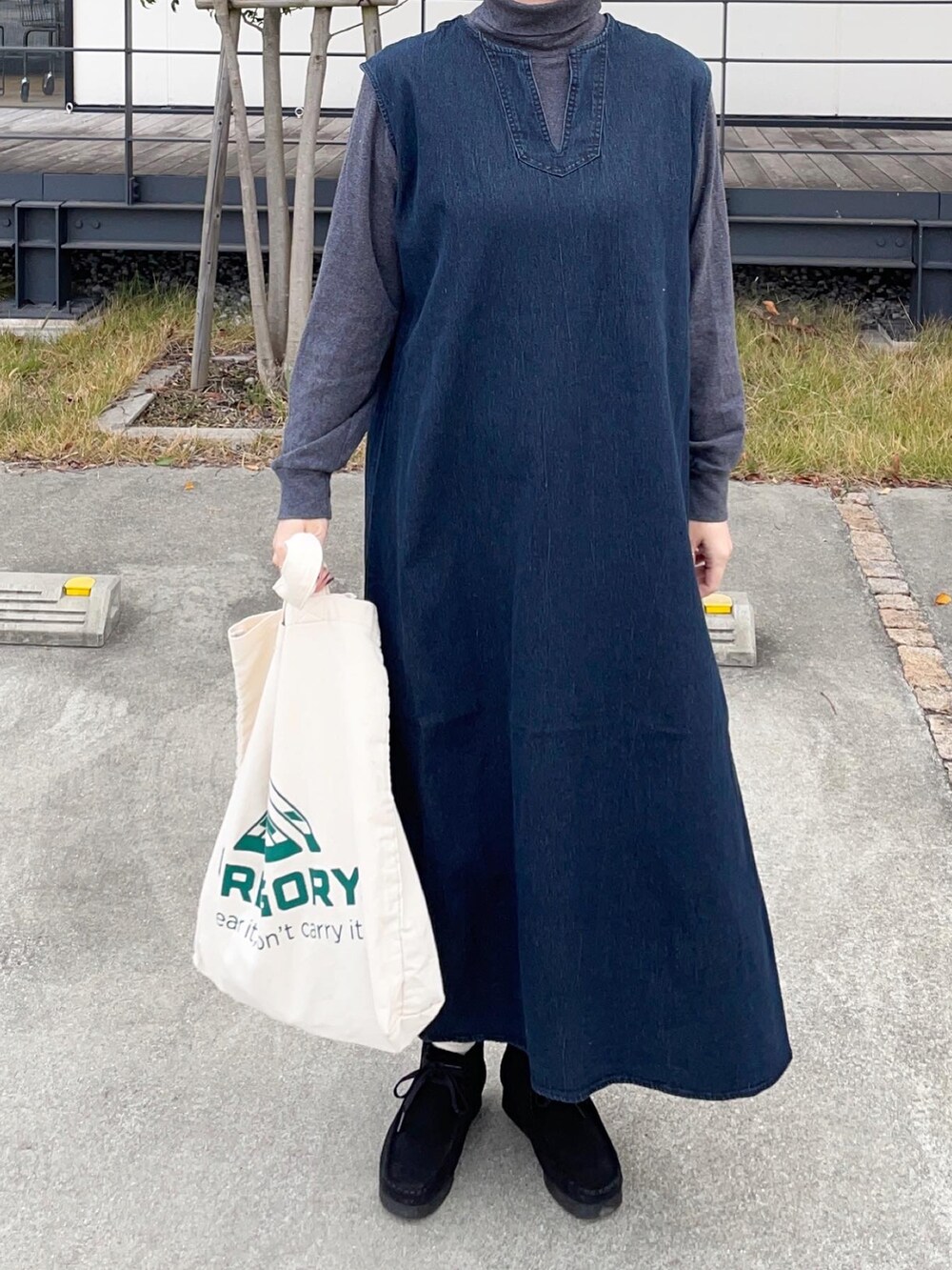 ブルー系のワンピース、ブラック系のブーツ、ホワイト系のトートバッグを着用したレディースの冬コーディネートの3枚目の写真