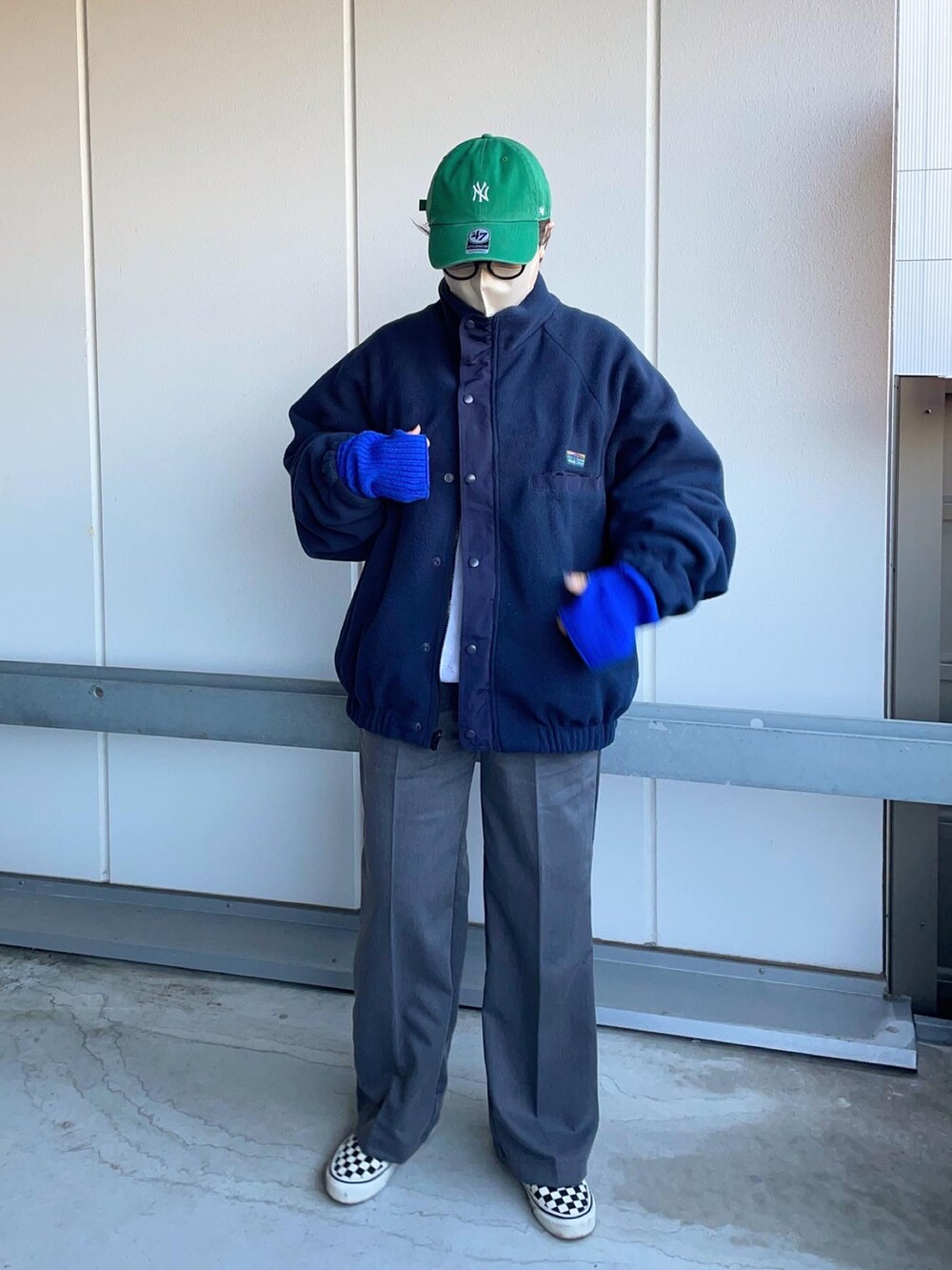 グレー系のスラックス、ブルー系のブルゾン、ホワイト系のスニーカーを着用したレディースの冬コーディネートの3枚目の写真