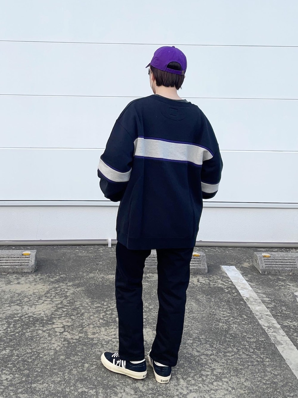 ブラック系のスニーカー、ブラック系のスウェット、ブラック系のデニムパンツを着用したレディースの冬コーディネートの2枚目の写真