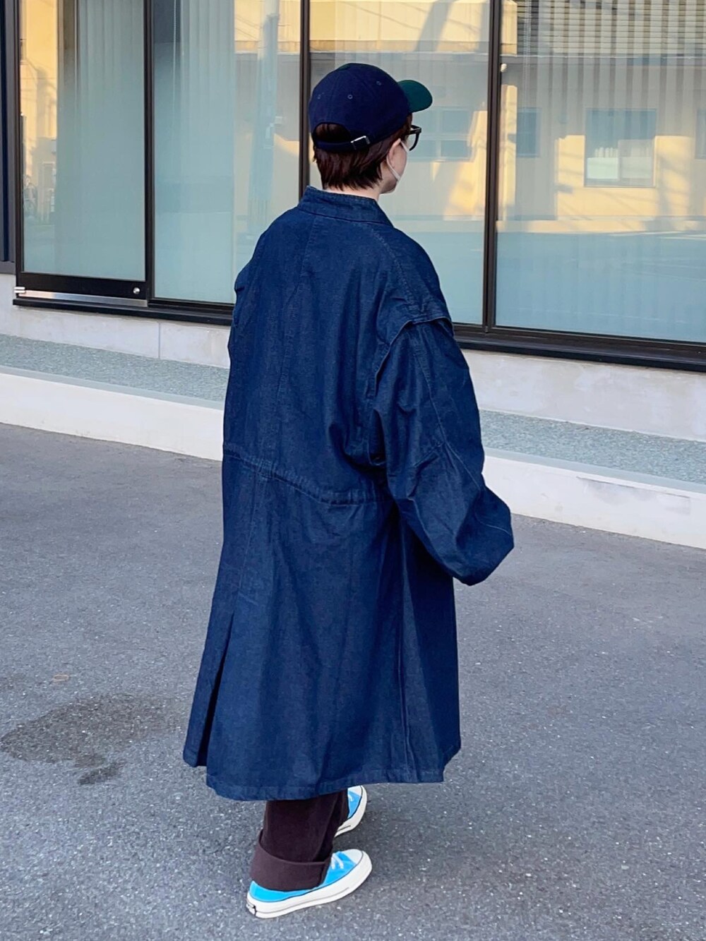 ブルー系のモッズコート、ブラウン系のパンツ、ホワイト系のTシャツ/カットソーを着用したレディースの秋コーディネートの2枚目の写真