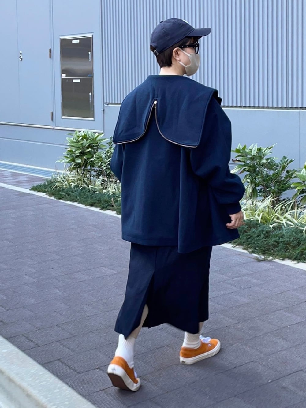 オレンジ系のスニーカー、ブルー系のブルゾン、ブラウン系のニット/セーターを着用したレディースの秋コーディネートの2枚目の写真