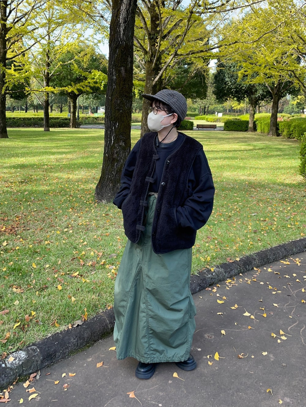 ブラック系のその他アウター、グリーン系のワンピース、ブラック系のブーツを着用したレディースの秋コーディネートの2枚目の写真