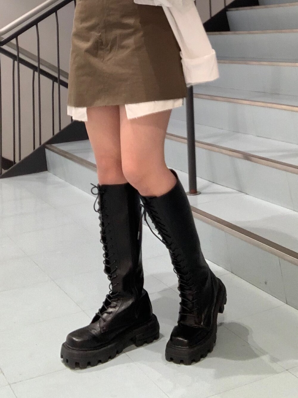 ブラック系のTシャツ/カットソー、ホワイト系のシャツ/ブラウス、グリーン系のスカートを着用したレディースの春コーディネートの7枚目の写真