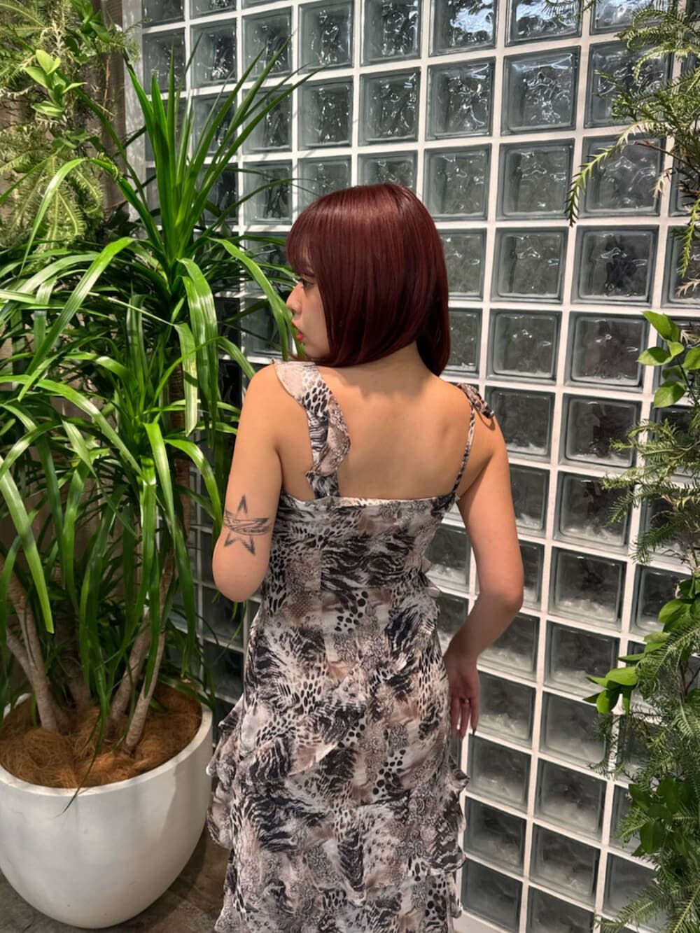 ベージュ系のワンピース、ブルー系のデニムパンツ、ホワイト系のサンダルを着用したレディースの春コーディネートの5枚目の写真