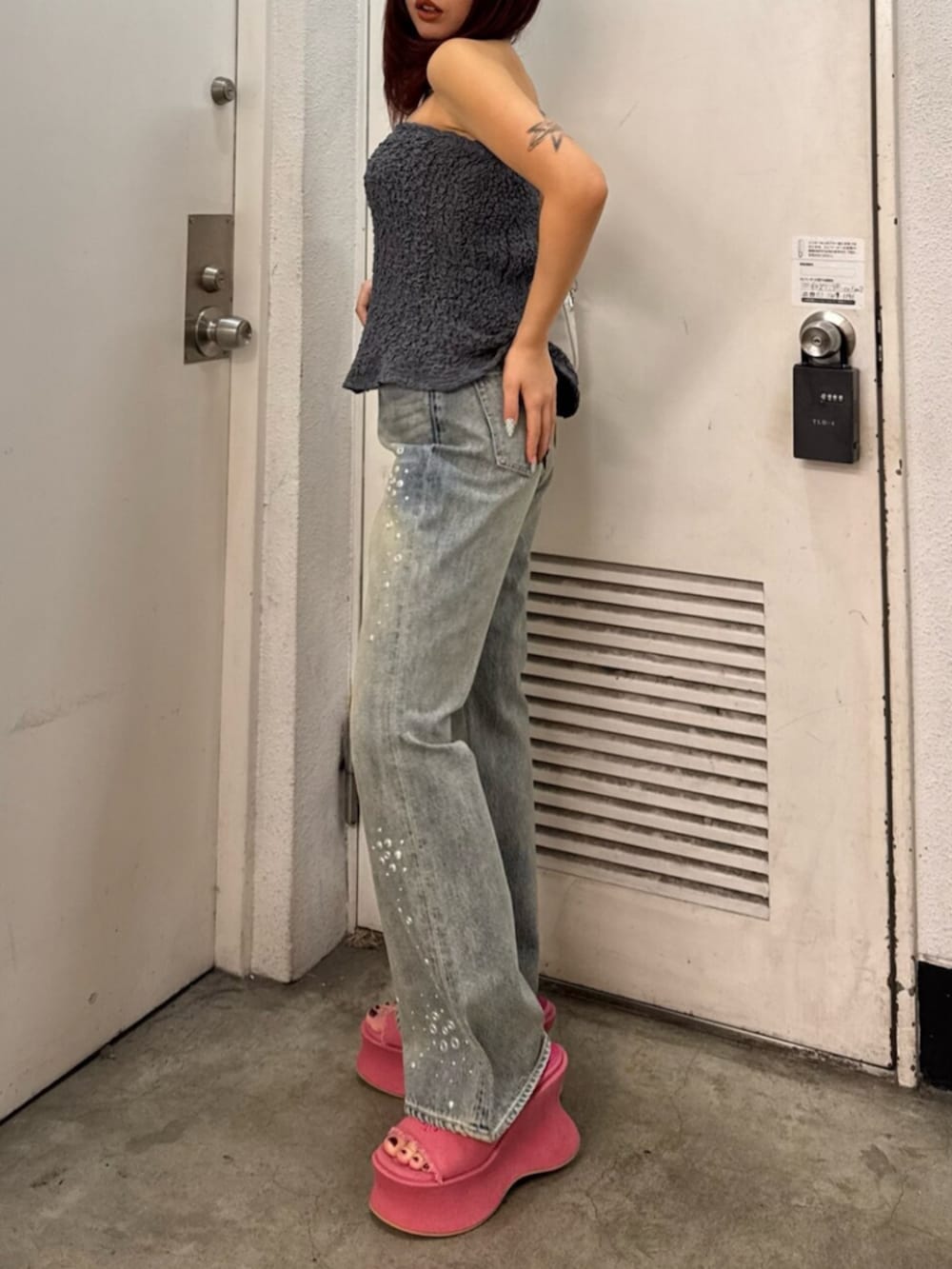 グレー系のキャミソール、ブルー系のデニムパンツ、ピンク系のサンダルを着用したレディースの春コーディネートの2枚目の写真