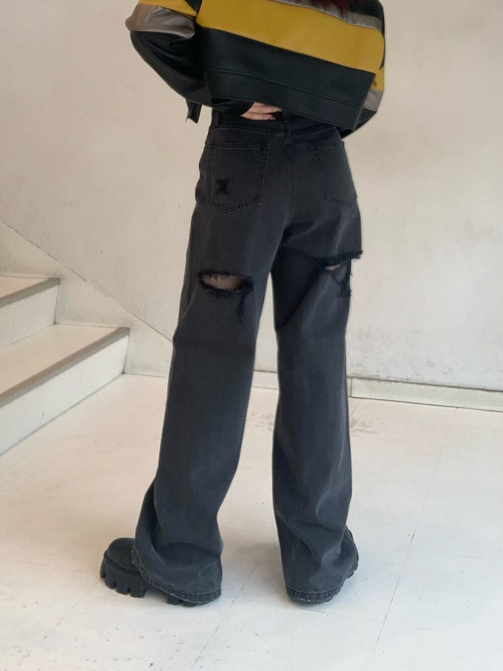 ブラック系のブルゾン、グレー系のTシャツ/カットソー、ブラック系のデニムパンツを着用したレディースの秋コーディネートの6枚目の写真