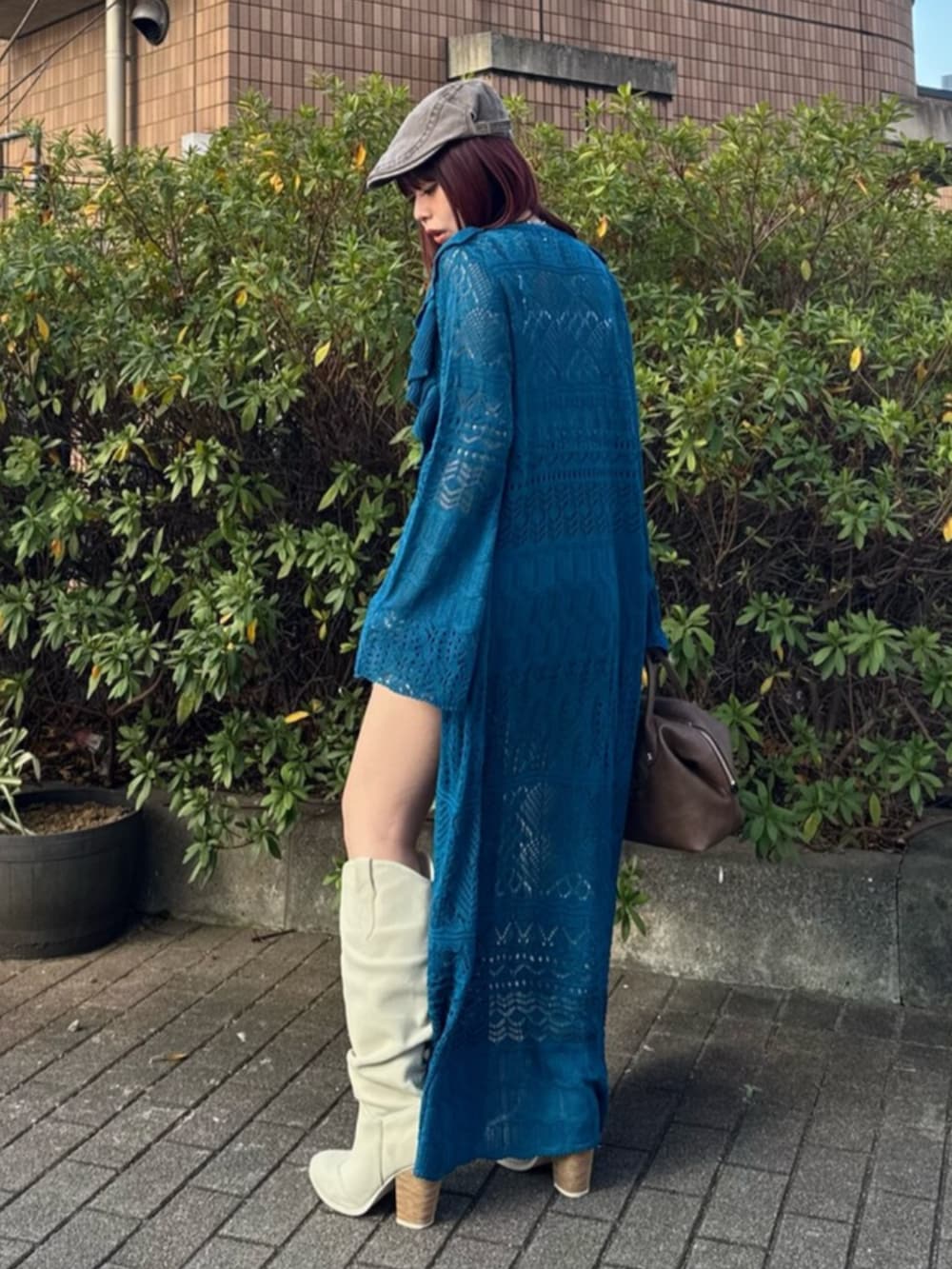 ブラウン系のボストンバッグ、ホワイト系のブーツ、ホワイト系のシャツ/ブラウスを着用したレディースの春コーディネートの3枚目の写真