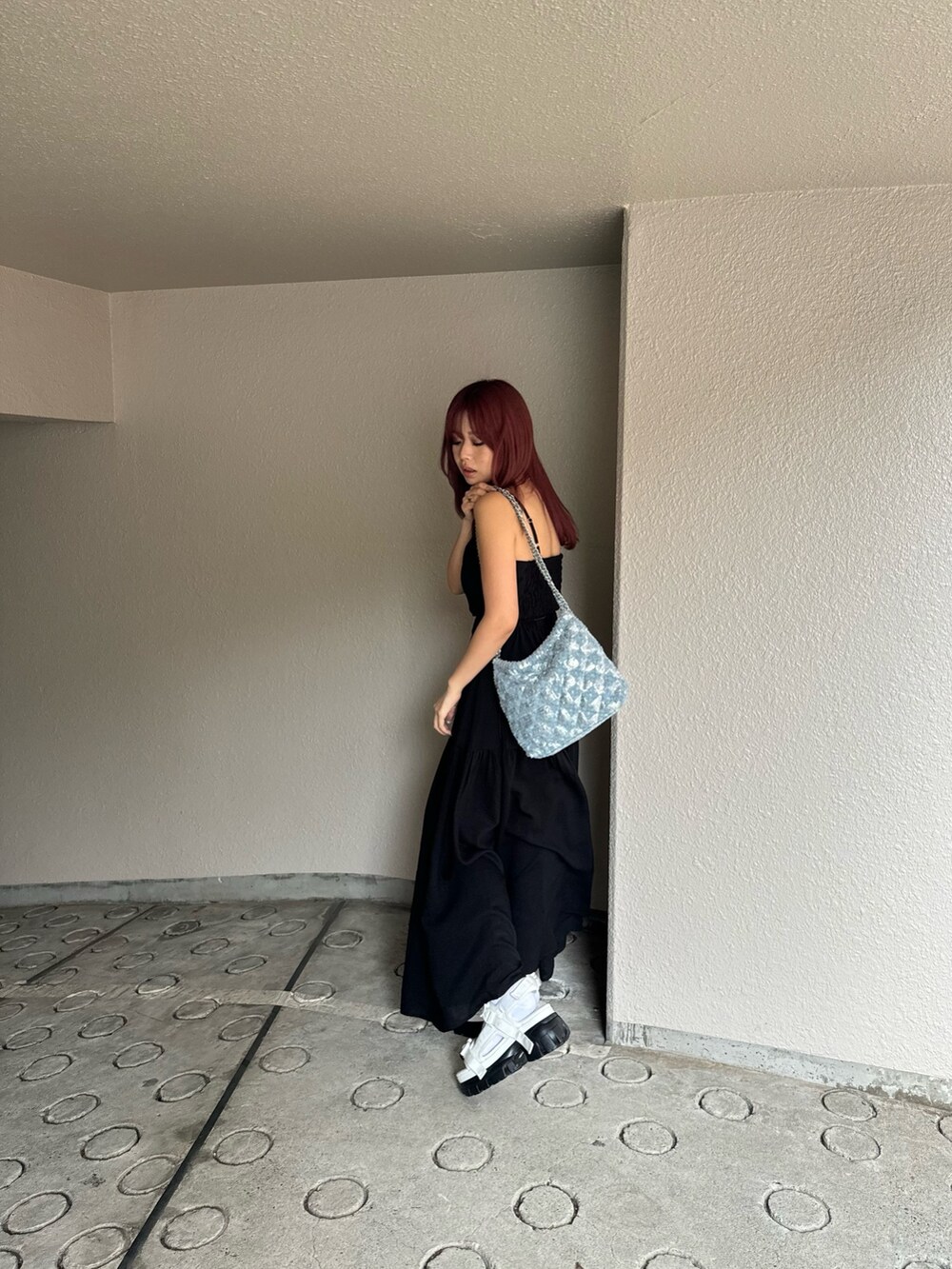 ホワイト系のサンダル、ブラック系のワンピースを着用したレディースの春コーディネートの3枚目の写真