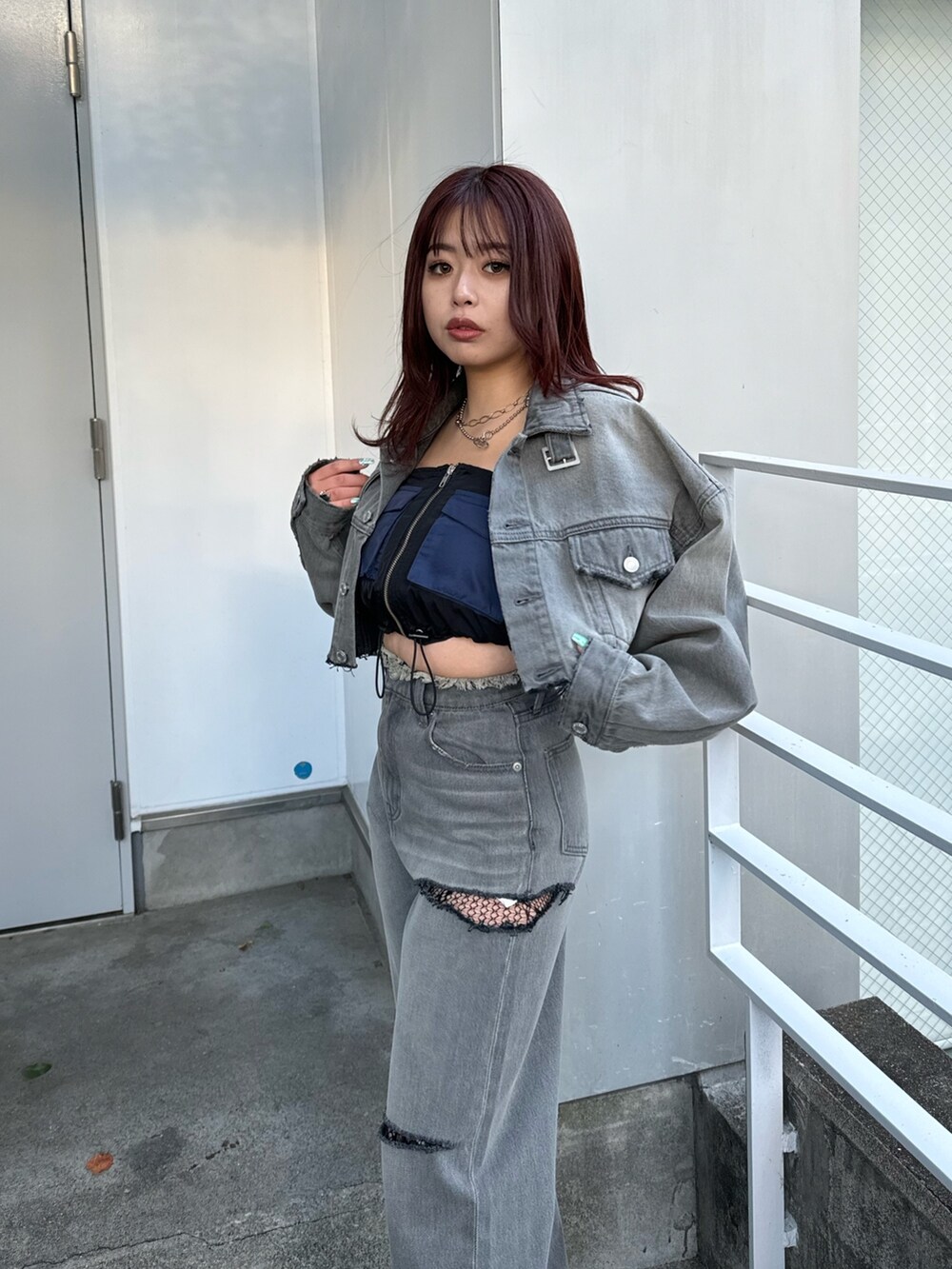 ブラック系のデニムパンツ、ブラック系のキャミソール、ブラック系のデニムジャケットを着用したレディースの冬コーディネートの4枚目の写真