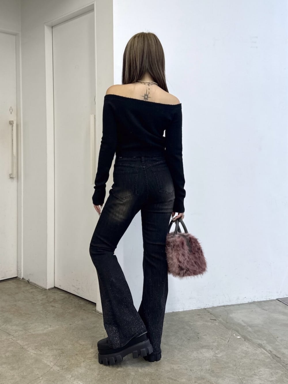 ブラック系のニット/セーター、ブラック系のデニムパンツ、ピンク系のボストンバッグを着用したレディースの夏コーディネートの3枚目の写真