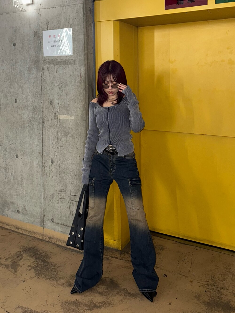 ブルー系のニット/セーター、ブルー系のデニムパンツ、ブラック系のパンプスを着用したレディースの夏コーディネートの3枚目の写真