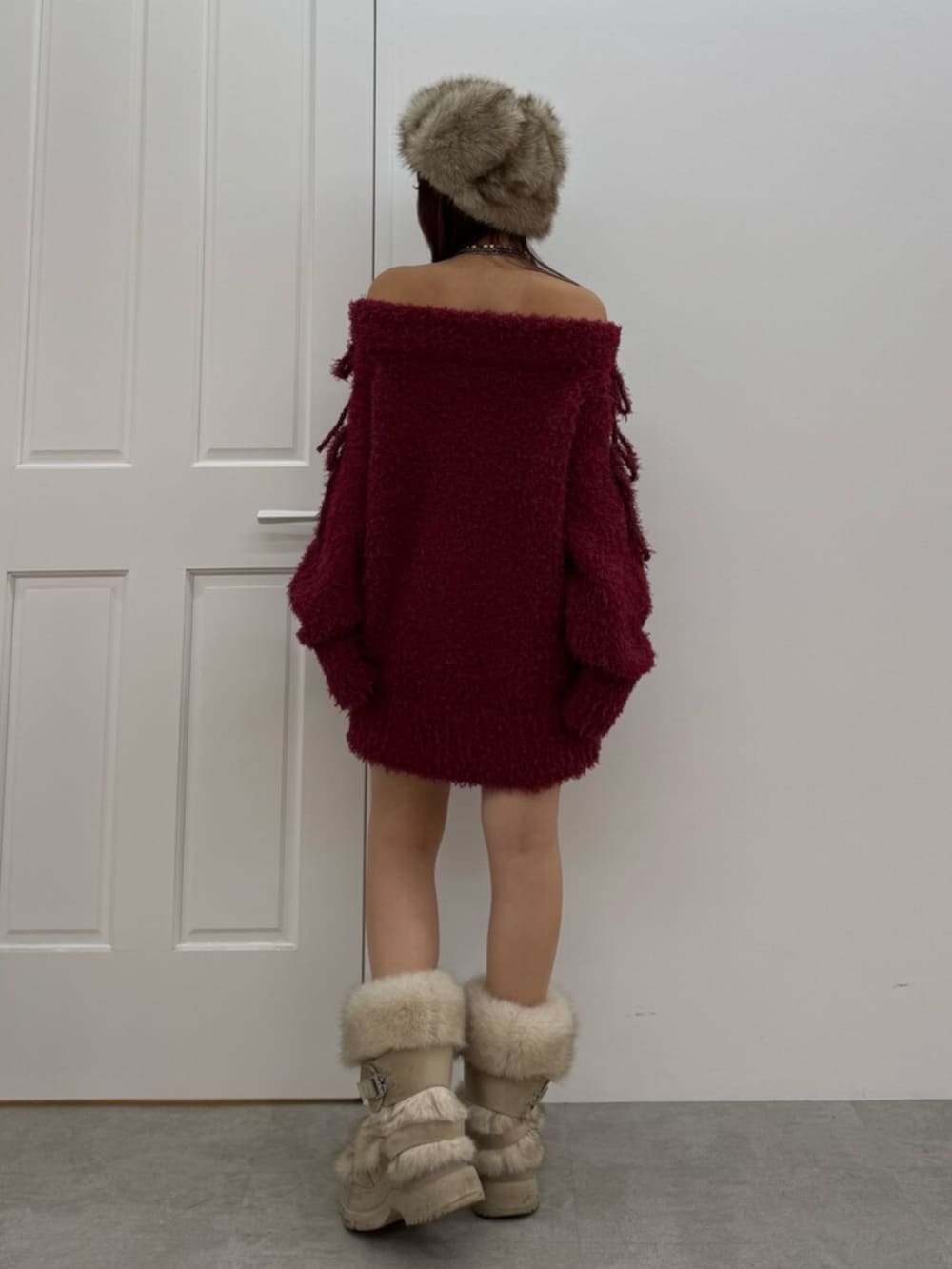 レッド系のワンピース、ベージュ系のキャップを着用したレディースの冬コーディネートの3枚目の写真