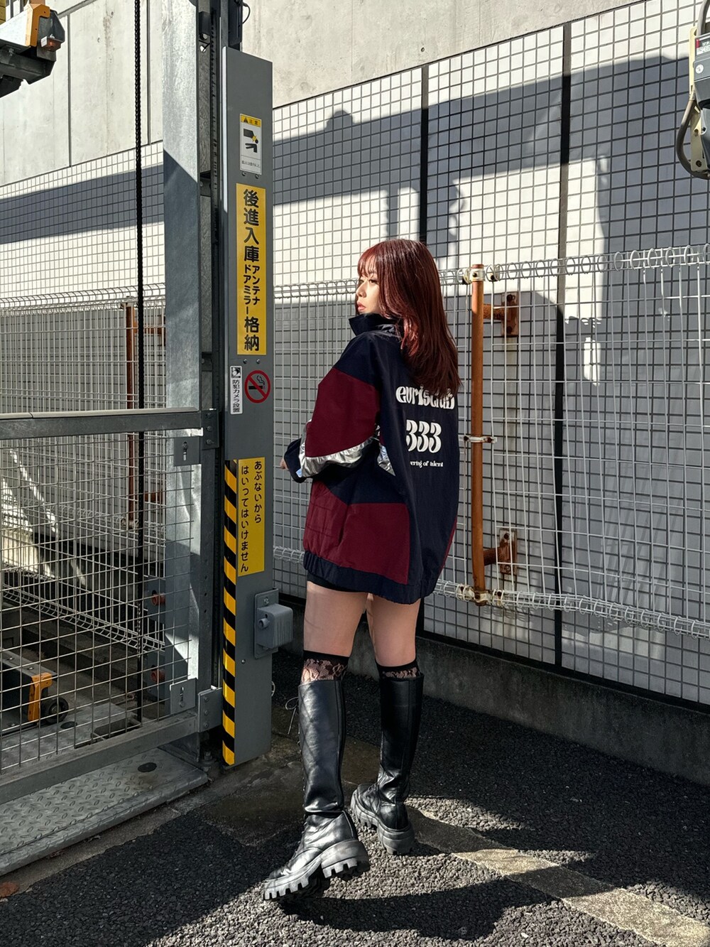 ブルー系のナイロンジャケット、グレー系のTシャツ/カットソー、シルバー系のショルダーバッグを着用したレディースの冬コーディネートの2枚目の写真
