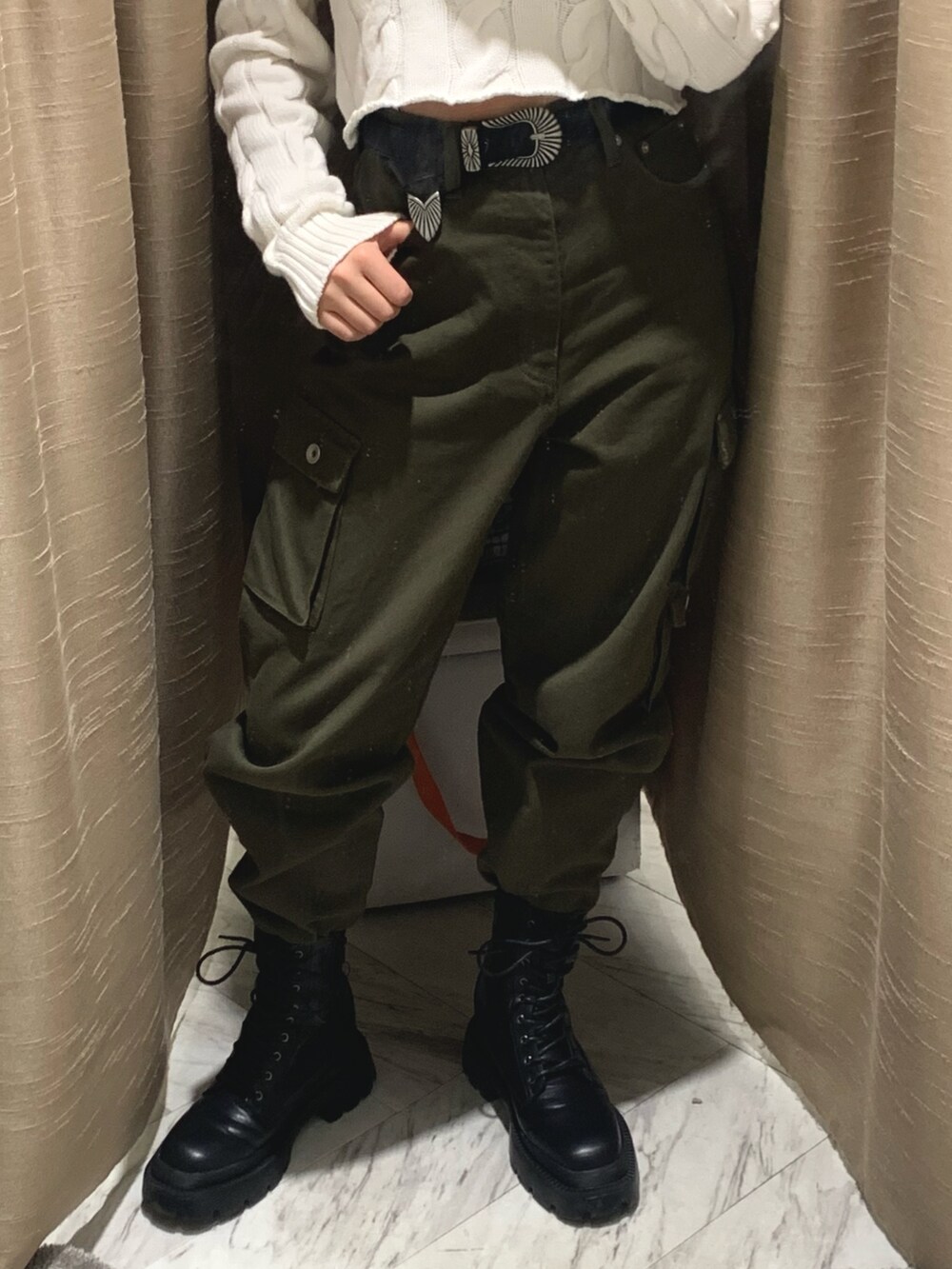 ホワイト系のカーディガン/ボレロ、グリーン系のデニムパンツ、ブラック系のブーツを着用したレディースの冬コーディネートの4枚目の写真