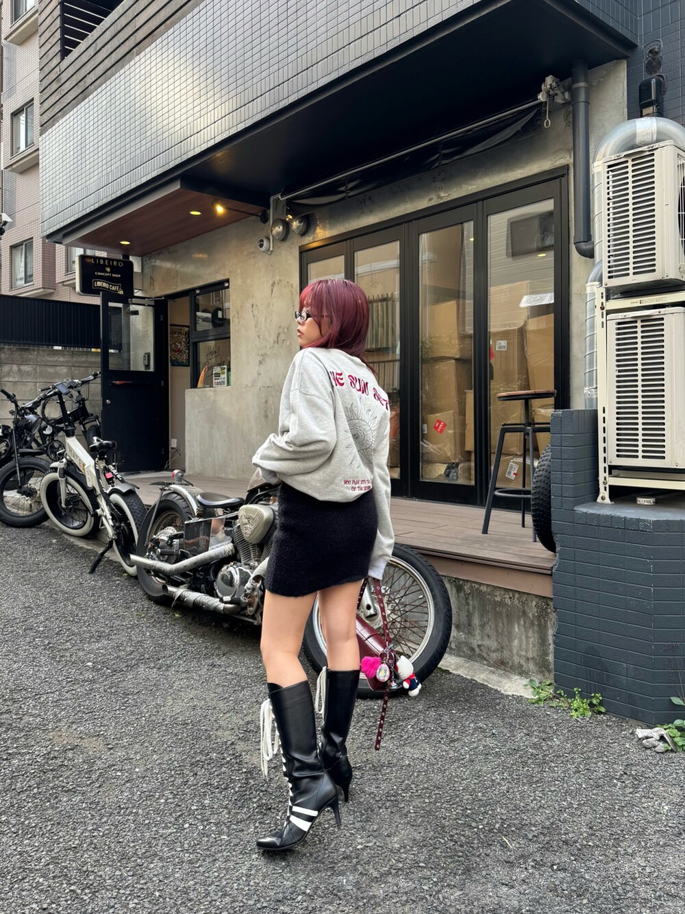 グレー系のスウェット、ブラック系のスカート、ブラック系のブーツを着用したレディースの冬コーディネートの2枚目の写真