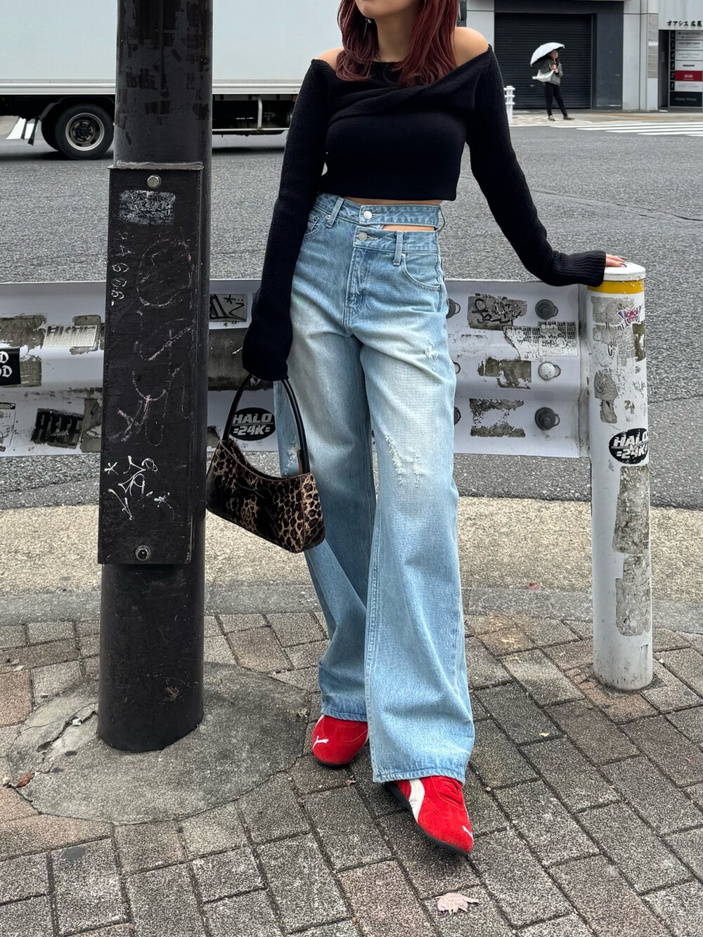 ブルー系のデニムパンツ、ブラック系のニット/セーター、レッド系のスニーカーを着用したレディースの冬コーディネートの3枚目の写真