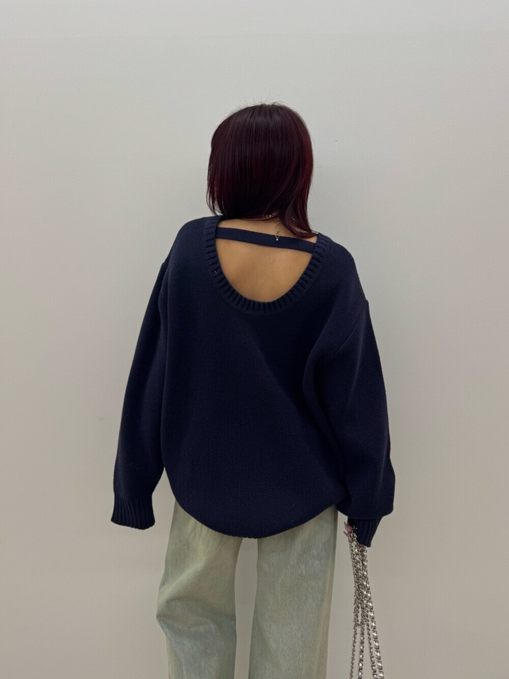 ブラック系のブーツ、ブルー系のニット/セーター、ブルー系のデニムパンツを着用したレディースの冬コーディネートの6枚目の写真