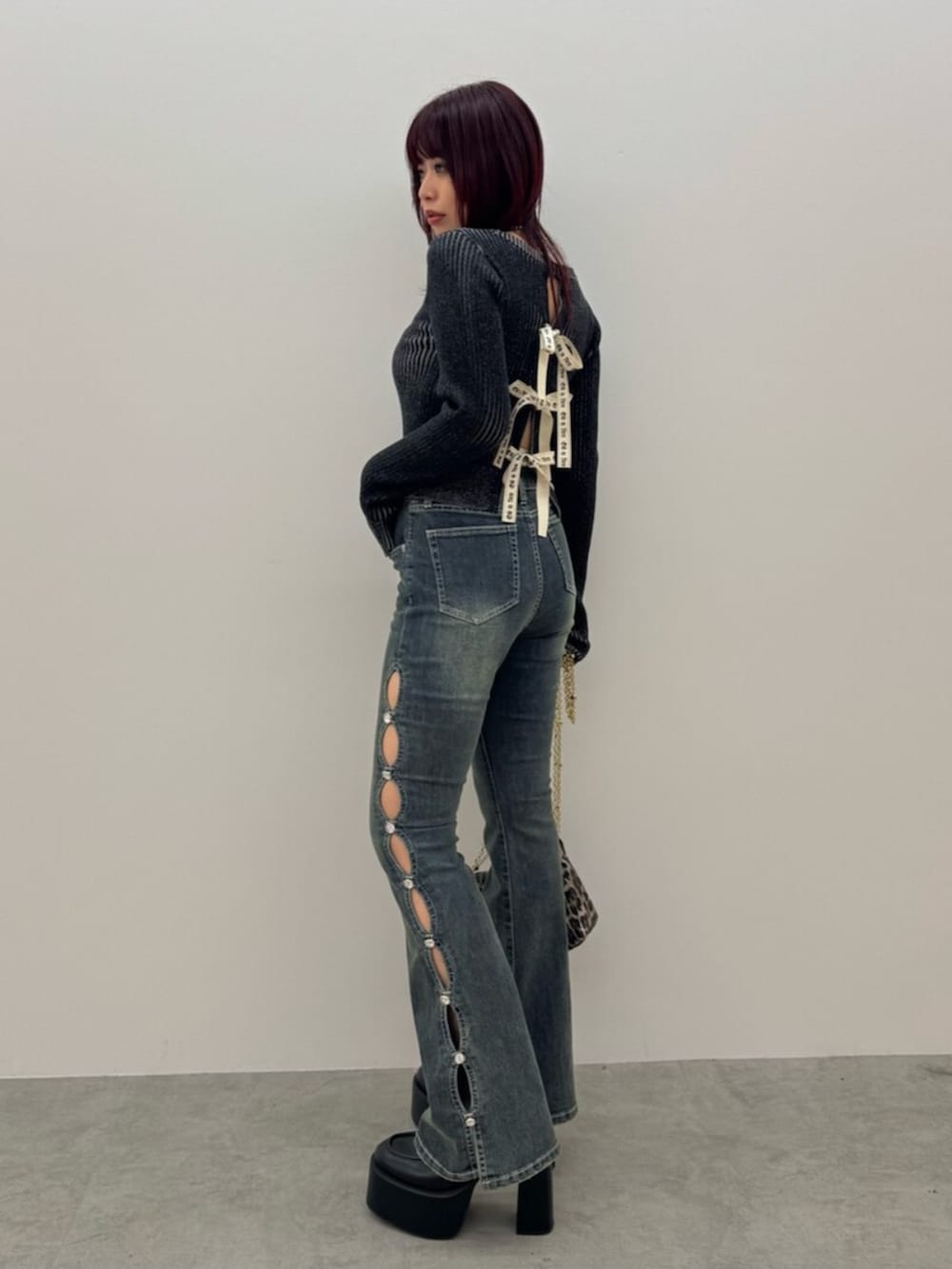 ブラック系のブーツ、ブラック系のニット/セーター、ブルー系のデニムパンツを着用したレディースの冬コーディネートの2枚目の写真