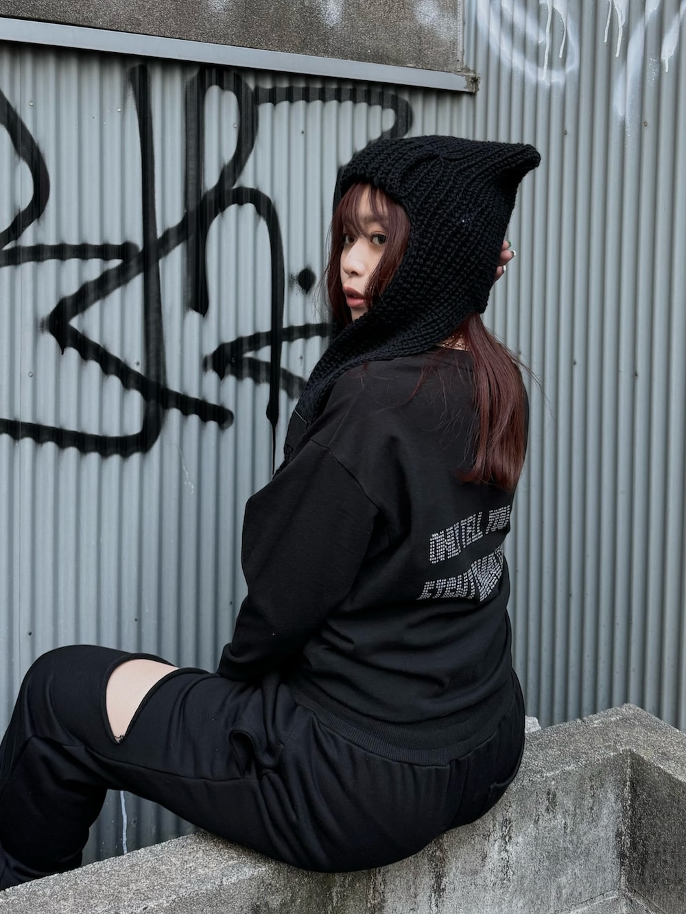 ブラック系のTシャツ/カットソー、ブラック系のスウェットパンツ、ブラック系のブーツを着用したレディースの冬コーディネートの5枚目の写真