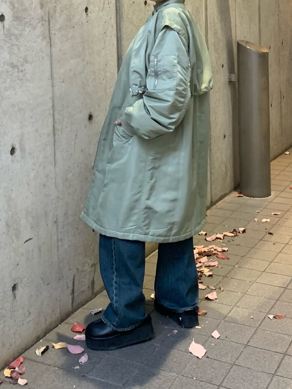 グリーン系のMA-1、ブルー系のデニムパンツ、ブラック系のスリッポンを着用したレディースの冬コーディネートの5枚目の写真