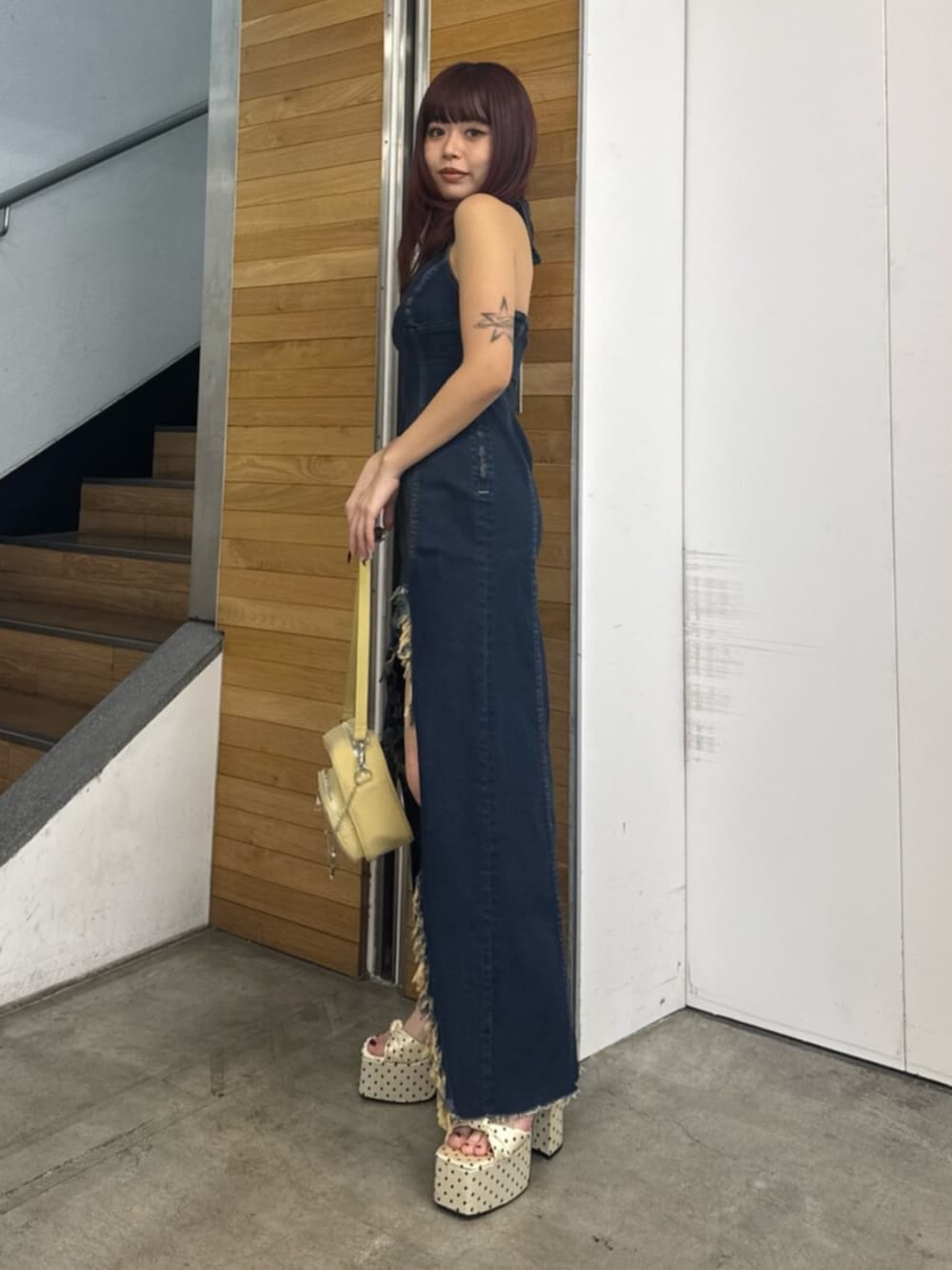 ブルー系のワンピース、イエロー系のハンドバッグ、ホワイト系のサンダルを着用したレディースの春コーディネートの2枚目の写真