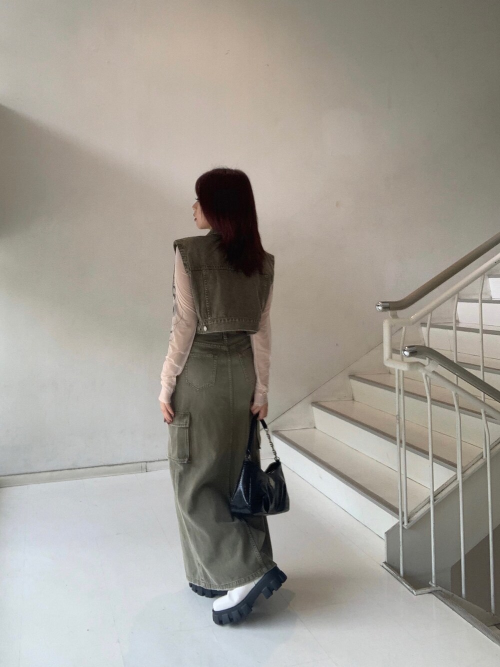 グリーン系のデニムジャケット、グリーン系のデニムスカート、ベージュ系のTシャツ/カットソーを着用したレディースの秋コーディネートの2枚目の写真