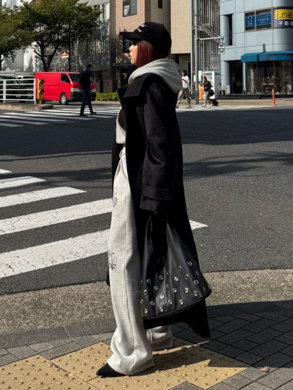 グレー系のスウェットパンツ、グレー系のパーカー、ブラック系のチェスターコートを着用したレディースの秋コーディネートの2枚目の写真