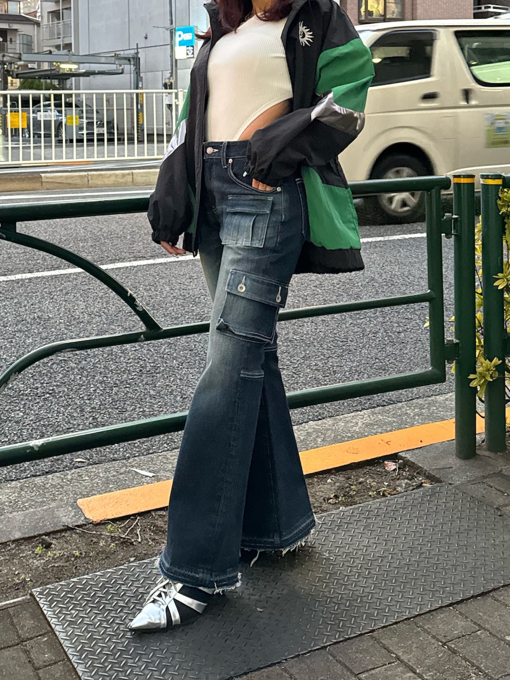 ブラック系のナイロンジャケット、ホワイト系のTシャツ/カットソー、ブルー系のデニムパンツを着用したレディースの冬コーディネートの2枚目の写真