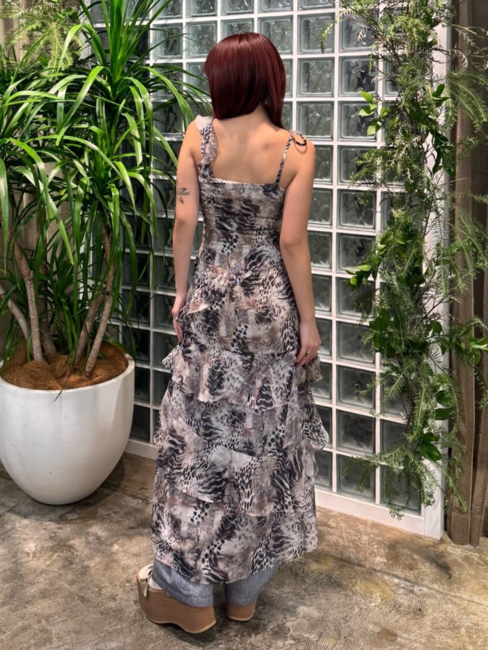 ベージュ系のワンピース、ブルー系のデニムパンツ、ホワイト系のサンダルを着用したレディースの春コーディネートの3枚目の写真