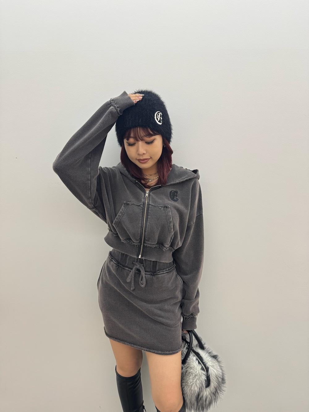 ブラック系のパーカー、ブラック系のスカート、ブラック系のボストンバッグを着用したレディースの秋コーディネートの4枚目の写真